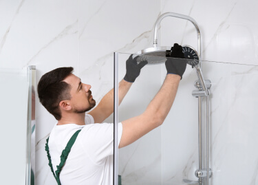 Plumber installing rainfall showerhead